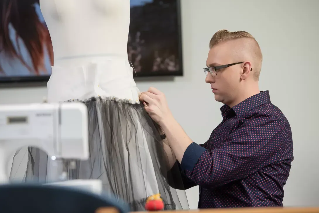 Fashion Merchandising student using a dress form