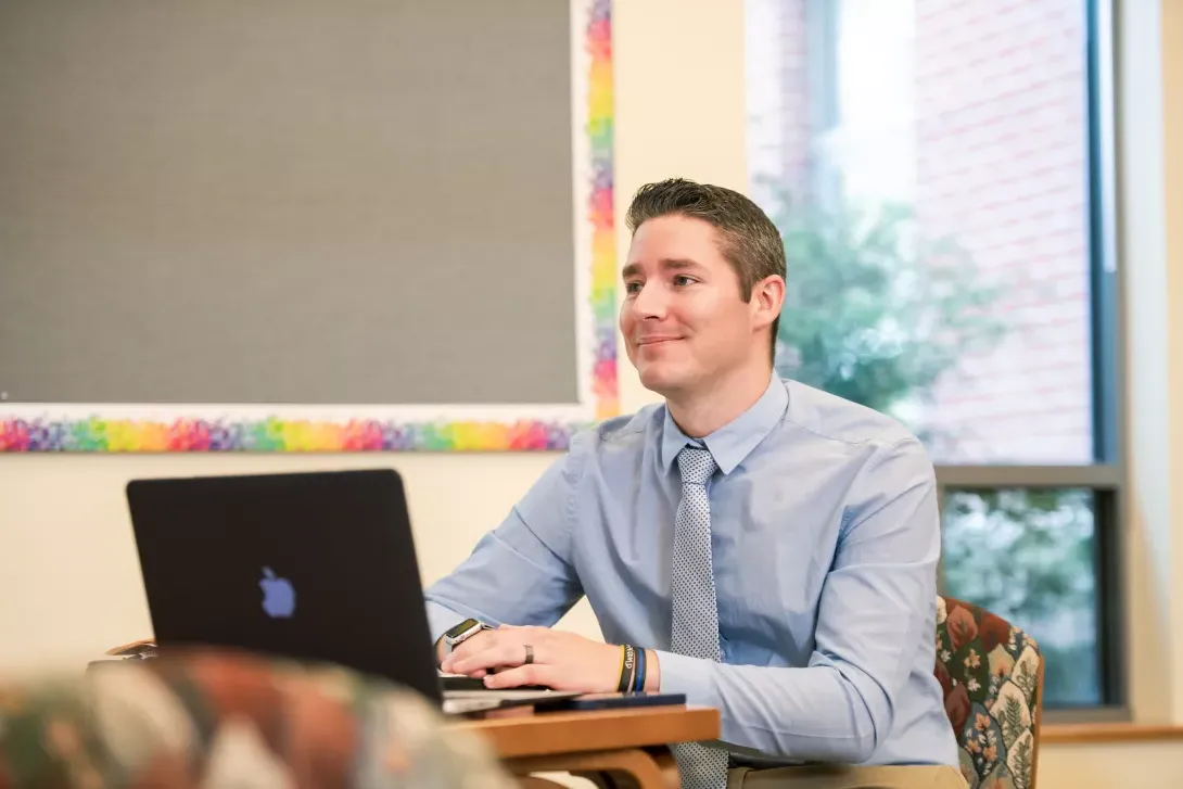 Superintendent licensure student at desk with laptop computer